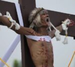 Clavado en una cruz, filipino reza para que termine la guerra en Ucrania