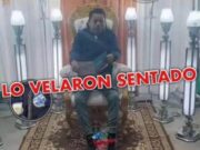 Velaron sentado a un docente con un libro en la mano