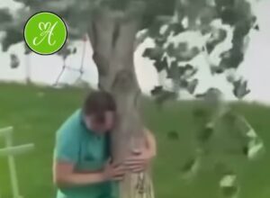 Un padre sostiene un árbol que había plantado su hija antes de morir